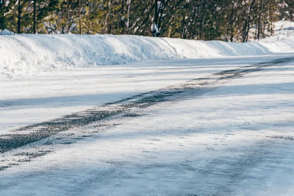 Snowy icy road. Danger of winter travel by road from ice