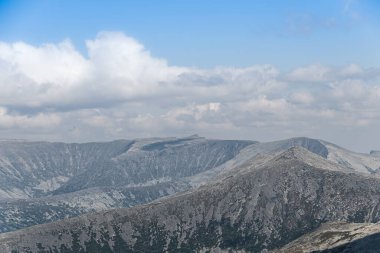 Mavi bulutlu gökyüzünün altında ufukta kayalık bir tepe var. Yolculuk için dağ vadisi. Macera seyahati, turizm ve koruma kavramı.