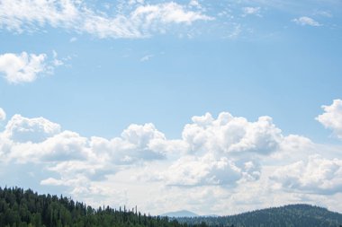 Mavi bulutlu gökyüzünün altında ufukta kayalık bir tepe var. Yolculuk için dağ vadisi. Macera seyahati, turizm ve koruma kavramı.