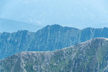 Dağ sıralarının panoramik manzarası. Kaya tırmanışı için çeşitli tepeleri olan kaya sırtı