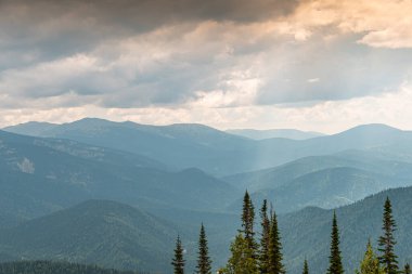 Sisli dağ vadisinin manzarası. Bulutların altında yumuşak tepeler.