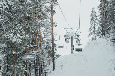 Karlı kış manzarasında sandalye kaldırma. Buz Ormanı 'nın üstündeki teleferik.