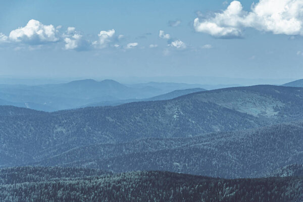Толстые облака над горным хребтом, холмы в голубой дымке