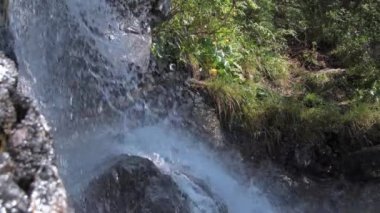 Uçurumdan düşen su jeti kayalara çarpıyor.