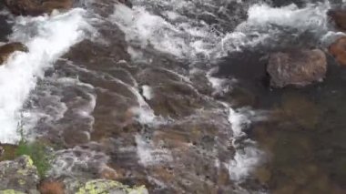 Fırtınalı dağ dereleri taştan yataklarda çağlıyor. Nehir granit duvar boyunca akar..