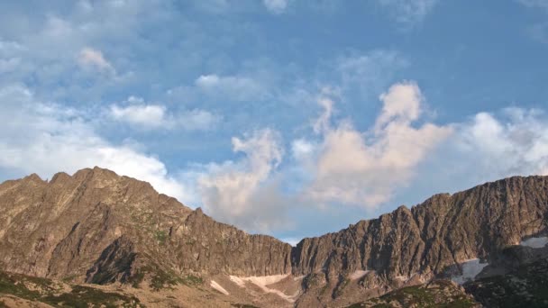 Cumulus wolken zweven over rotsachtige bergkam in de blauwe lucht — Stockvideo