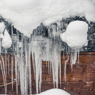 Sarkıt grubu ahşap evlerin saçaklarından sarkıyor