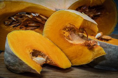 Ahşap masada çekirdekli büyük balkabağı parçaları. Salata ve taze meyve suyu için sebzeler. Sağlıklı vejetaryen yemekleri. Çiftçi işlem için balkabağı hazırladı.