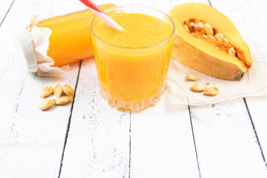 Sebzelerden oluşan sağlıklı bir kahvaltı. Bir bardak taze meyve suyu, bir şişe ve tohumlu bir parça balkabağı. Bahçeden çiftçi ürünleri