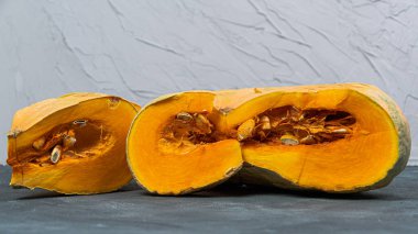 Pieces of pumpkin with seeds on table. Farmer autumn harvest. Cooking vegetable dishes. Vegetarian fair. Gardening, growing healthy food yourself for hobbies