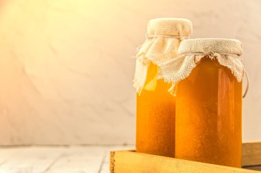 Bottles of orange fresh juice with pulp are ready for sale. Lids are covered with fabric, rustic style. Fortified drink. Copy space for text