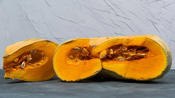 Pieces of pumpkin with seeds on table. Farmer autumn harvest. Cooking vegetable dishes. Vegetarian fair. Gardening, growing healthy food yourself for hobbies