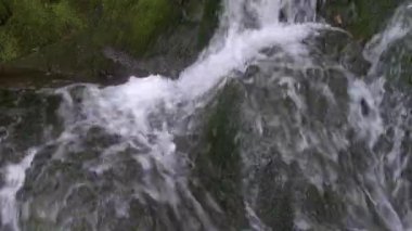 Su akıntısı kayayı kaplar. Damlalar ve jetler birbirinden ayrılır