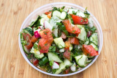 Rustik ahşap masa üstü görünümünde sağlıklı salata diyet. Karışık yeşillik, domates, salatalık, zeytin yağı ve baharat sağlıklı yaşam konsepti için.