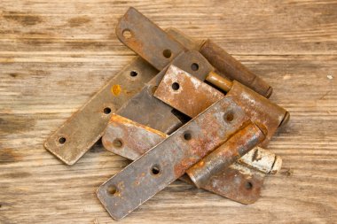Metal door hinge on a grungy wooden background