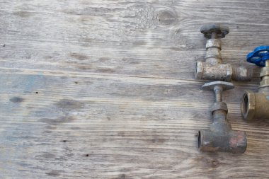 Plumber pipes on a grungy wooden background