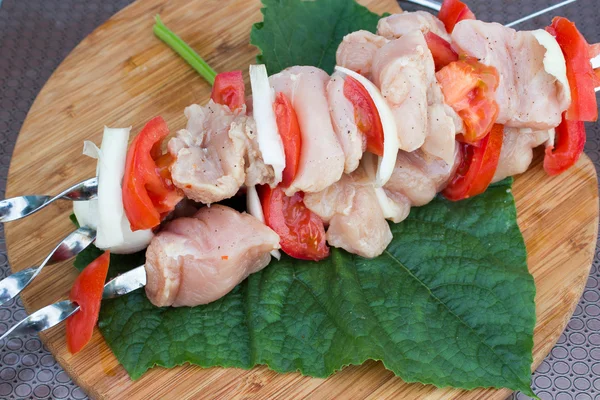 Skewered su bastoncini di legno gustosa carne di maiale e verdure mescolano shashlik preparato per grigliate sul piatto — Foto Stock