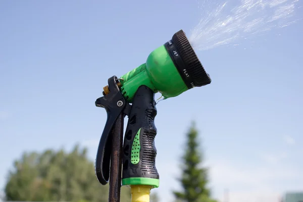 Watering lawn grass with a shower sprayer head — Stock Fotó
