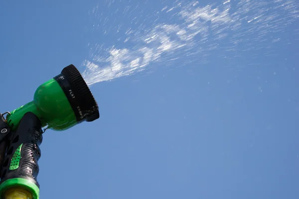 Watering lawn grass with a shower sprayer head — 스톡 사진