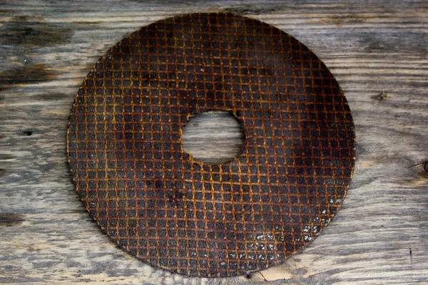 Circular saw blade. Abrasive disk for metal cutting work on a grungy wooden background — Stock Photo, Image