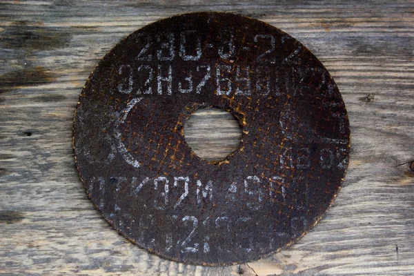 Circular saw blade. Abrasive disk for metal cutting work on a grungy wooden background — Stock Photo, Image