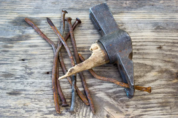 Vecchia curva dei chiodi e del tiraunghie su uno sfondo di legno — Foto Stock