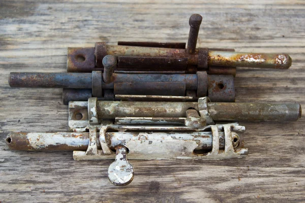 Old metal latch for the door on wooden table — Stock Photo, Image