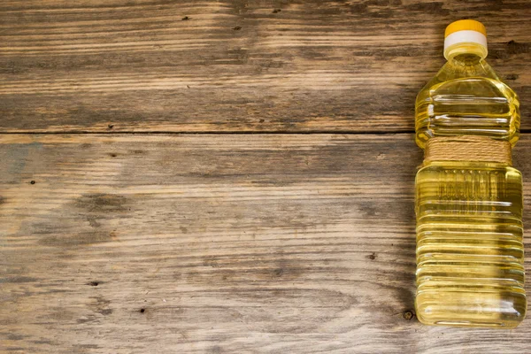 Bottle of sunflower oil on wooden background. Copy space to right. — 图库照片