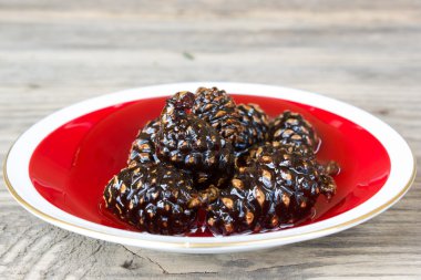 Yeşil çam kozalakları eski ahşap masa üzerinde reçel