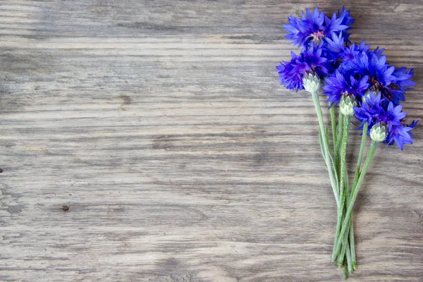 Cornflowers on the old wooden table, rustic with copy space — Stock Photo, Image