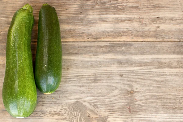 Zucchinis on wood background with copy space — Stock Photo, Image