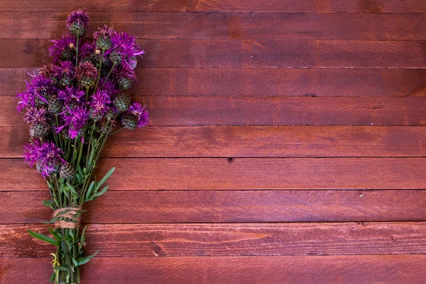 Burdock flowers on a wooden with copy space — Stock Photo, Image