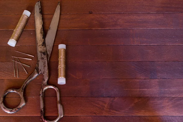 Старі ножиці, кульки і голки на дерев'яному столі — стокове фото