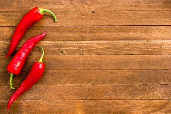 Piments rouges sur une vieille table en bois, espace de copie — Photo