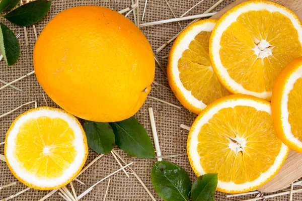 Verse sinaasappelen op jute zak achtergrond — Stockfoto