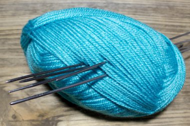 Skein kabarık mavi iplik, metal ile ahşap masa üzerinde tekerlek parmağı