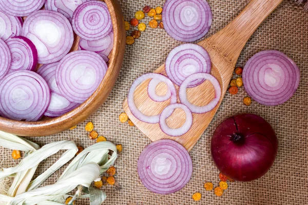 Cebollas rojas picadas en cuchara de madera sobre tela de saco, como fondo —  Fotos de Stock