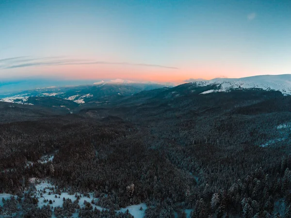 Parlak günbatımı manzarası dağlarda, havadan. Kış kar manzarası