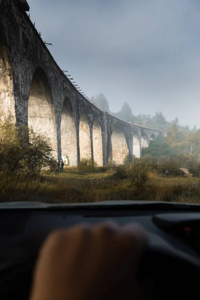 Eski köprü şafak vakti bir arabanın ön camından dağlarda viyadük.