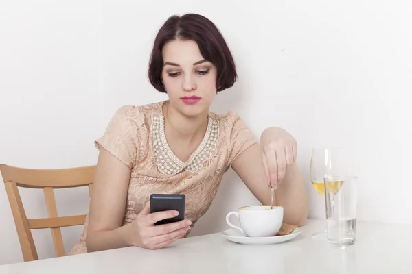 Woman looks disappointed to her mobile phone — Stock Photo, Image