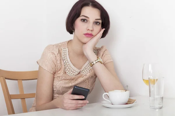 Vrouw ziet teleurgesteld naar haar mobiele telefoon — Stockfoto