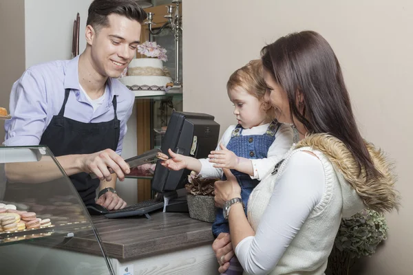 Moeder en kind aan de kassa van een winkel gebak — Stockfoto