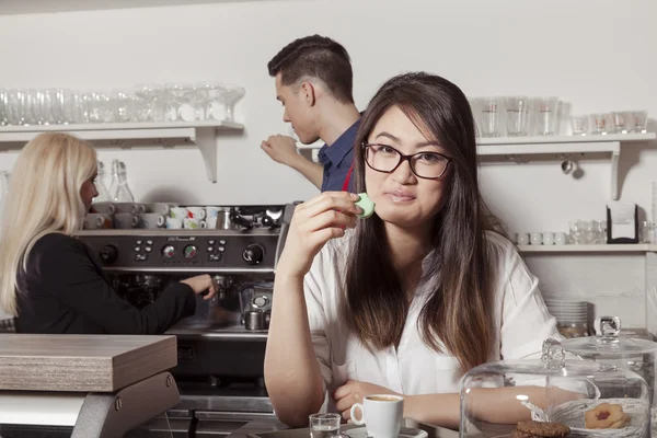 Aziatische vrouw met Frans macaroon — Stockfoto