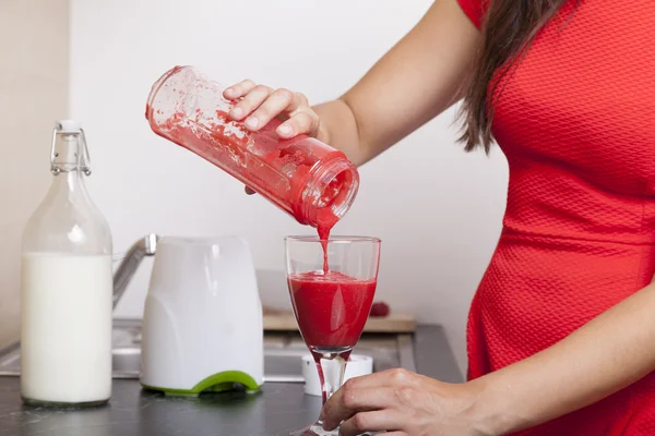 Žena výplně smíšených ovocný koktejl do skla — Stock fotografie
