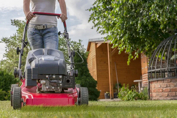 Cortacésped conducido por una jardinera anónima —  Fotos de Stock