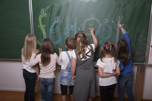 Escola meninas escrevendo no quadro negro — Fotografia de Stock
