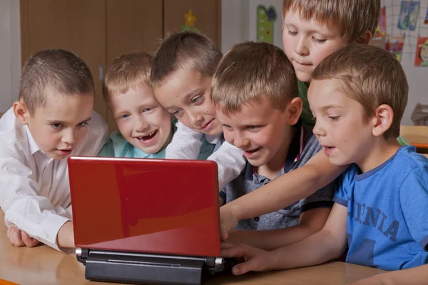 Koulupojat kannettavan tietokoneen kanssa — kuvapankkivalokuva