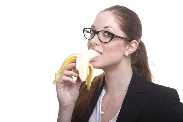 Businesswoman eats a banana — Stock Photo, Image