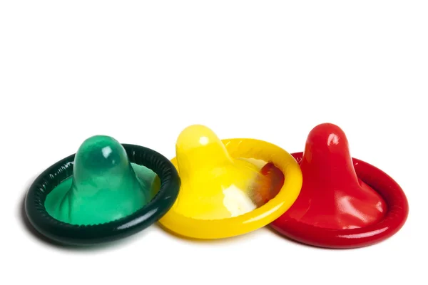 Três preservativos coloridos sobre fundo branco — Fotografia de Stock