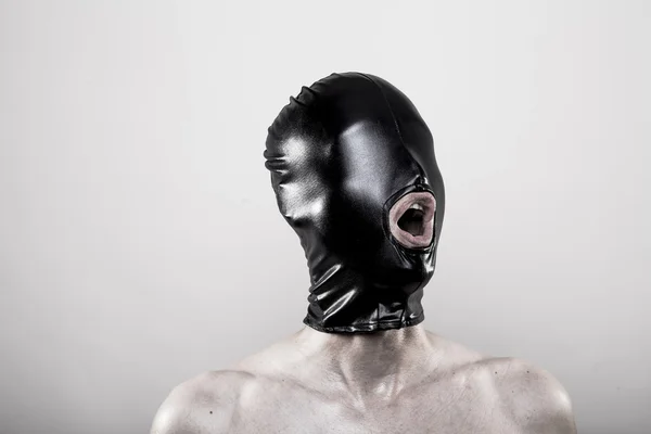 Человек в черной резиновой маске с завязанными глазами — стоковое фото
